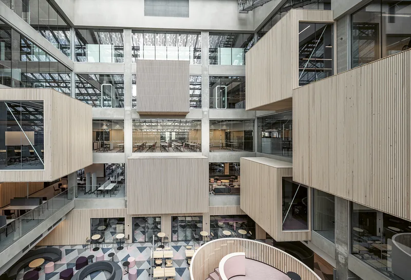 EduCity's multi-storey atrium with timber-clad meeting boxes, glass balconies and a lounge on the ground floor.